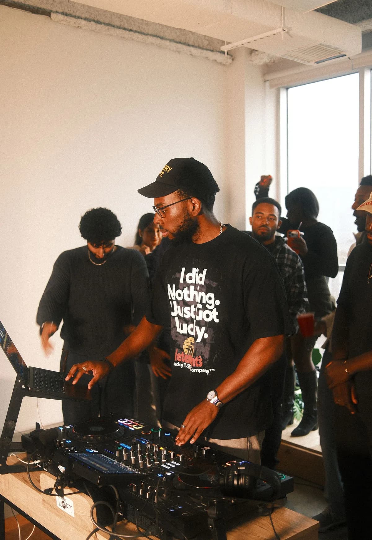 A DJ in a black cap and graphic tee mixing at OTL Sessions vol. 1.