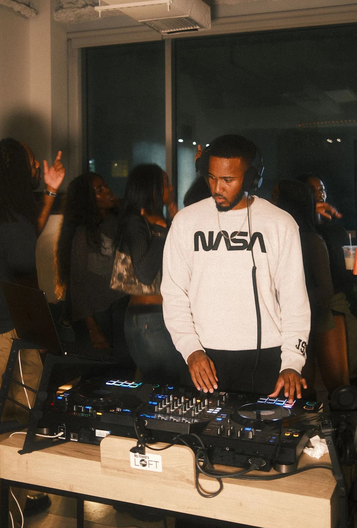 The DJ in a white hoodie on the decks at OTL Sessions vol. 1.